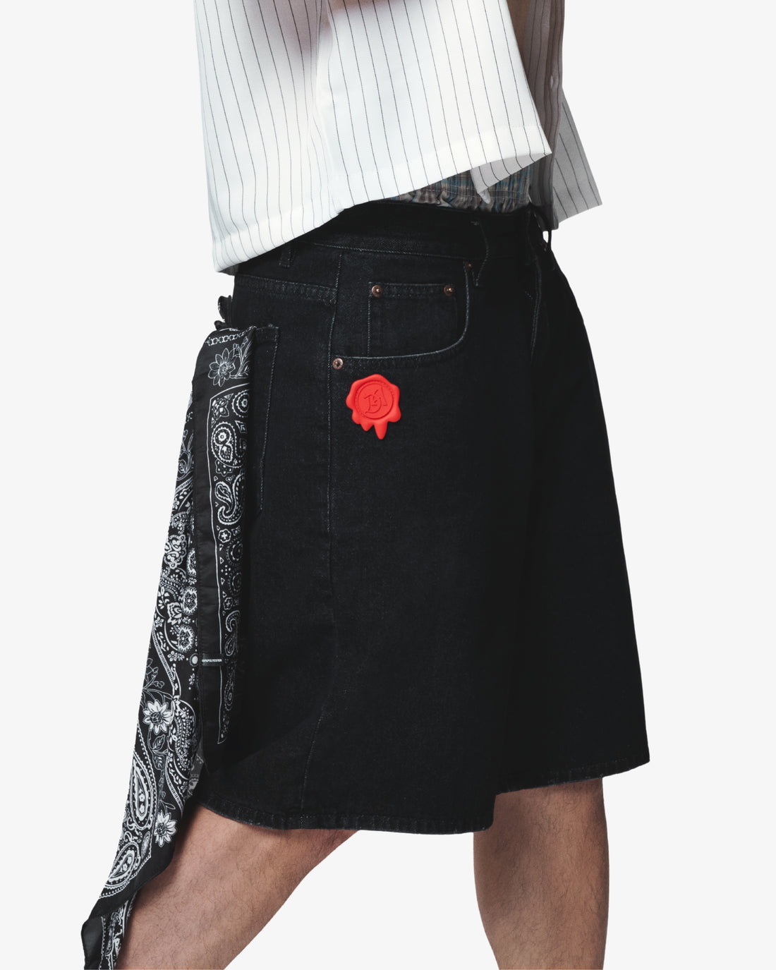 Black denim shorts with a rose patch and bandana on a white background
