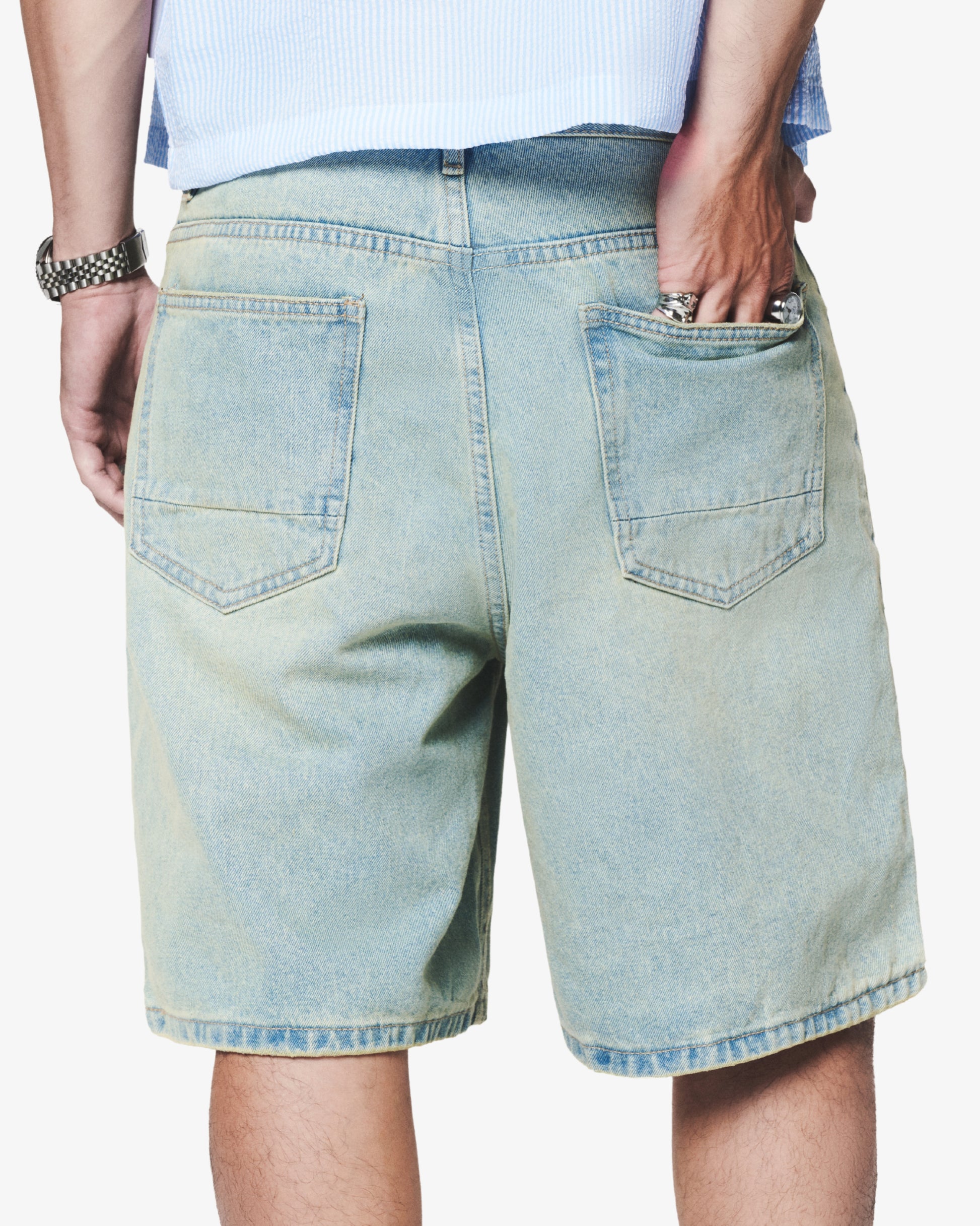 Light blue denim shorts worn by a person on a white background