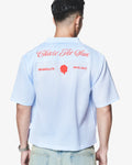 Light blue shirt with text on the back worn by a person, white background